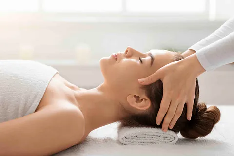 Masseurin macht entspannende Kopfmassage